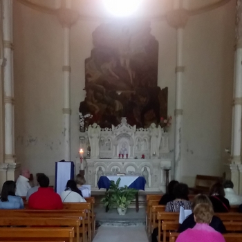 gens assis devant autel de chapelle