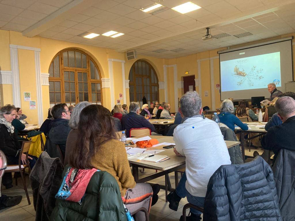 ensemble de personnes assises dans une salle d'étude écoutant un enseignement de Dominique Fontanet