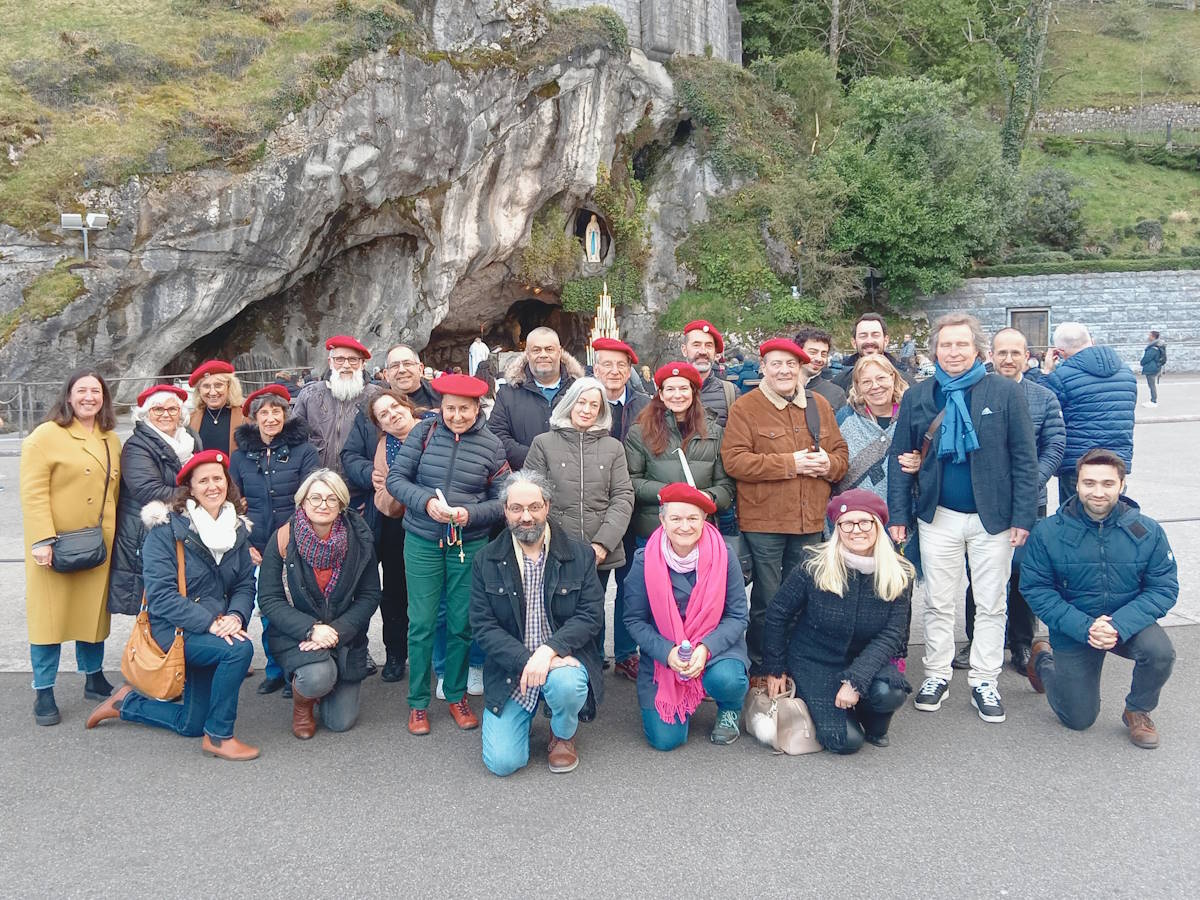 groupe de personnes posant la grotte de Lourdes